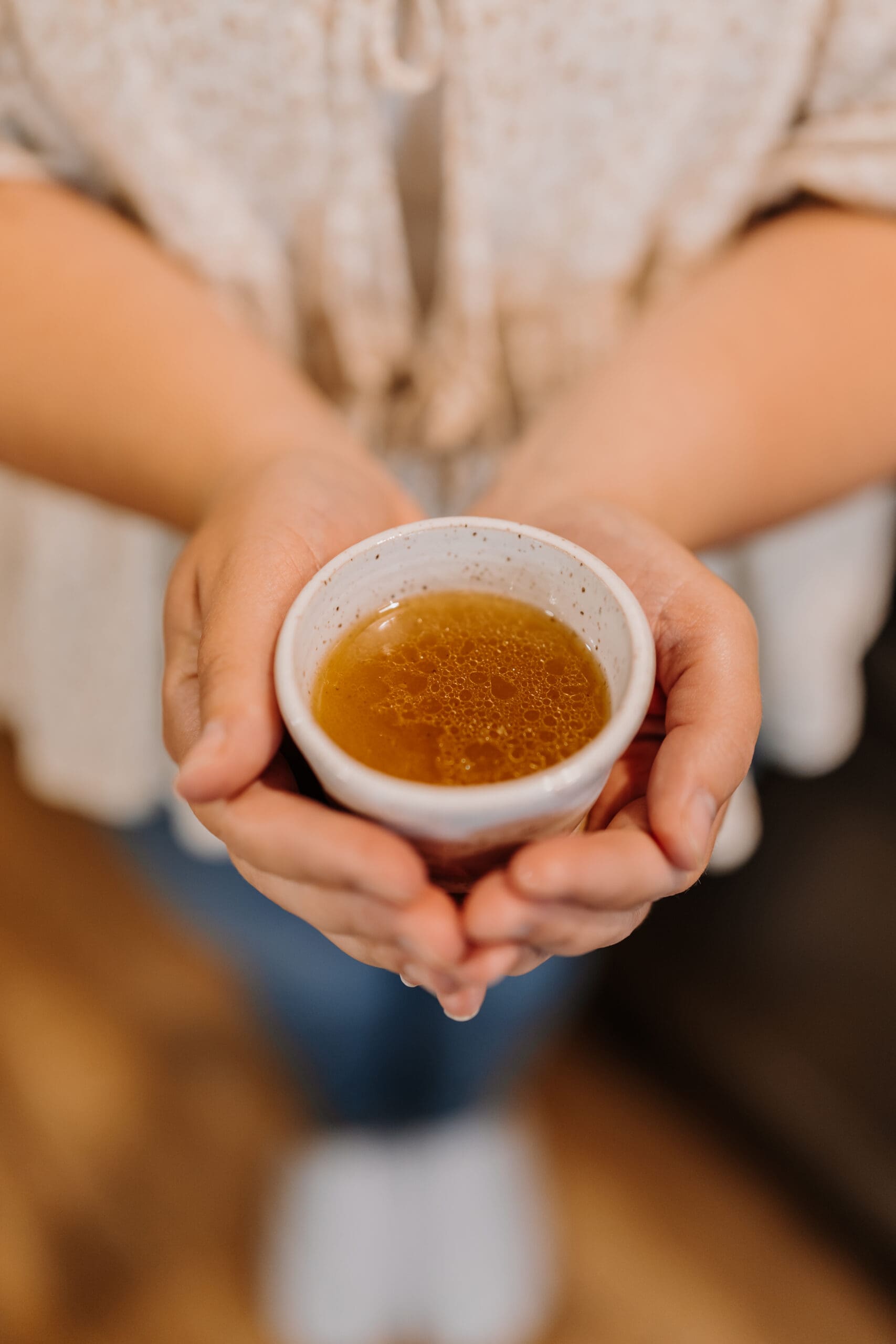 Kenna holding bone broth in a cup